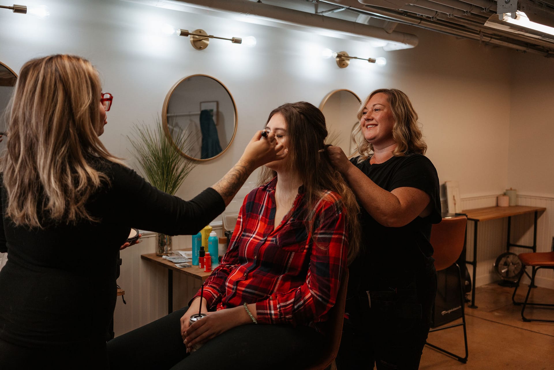 makeup artist and hair stylist working on bride