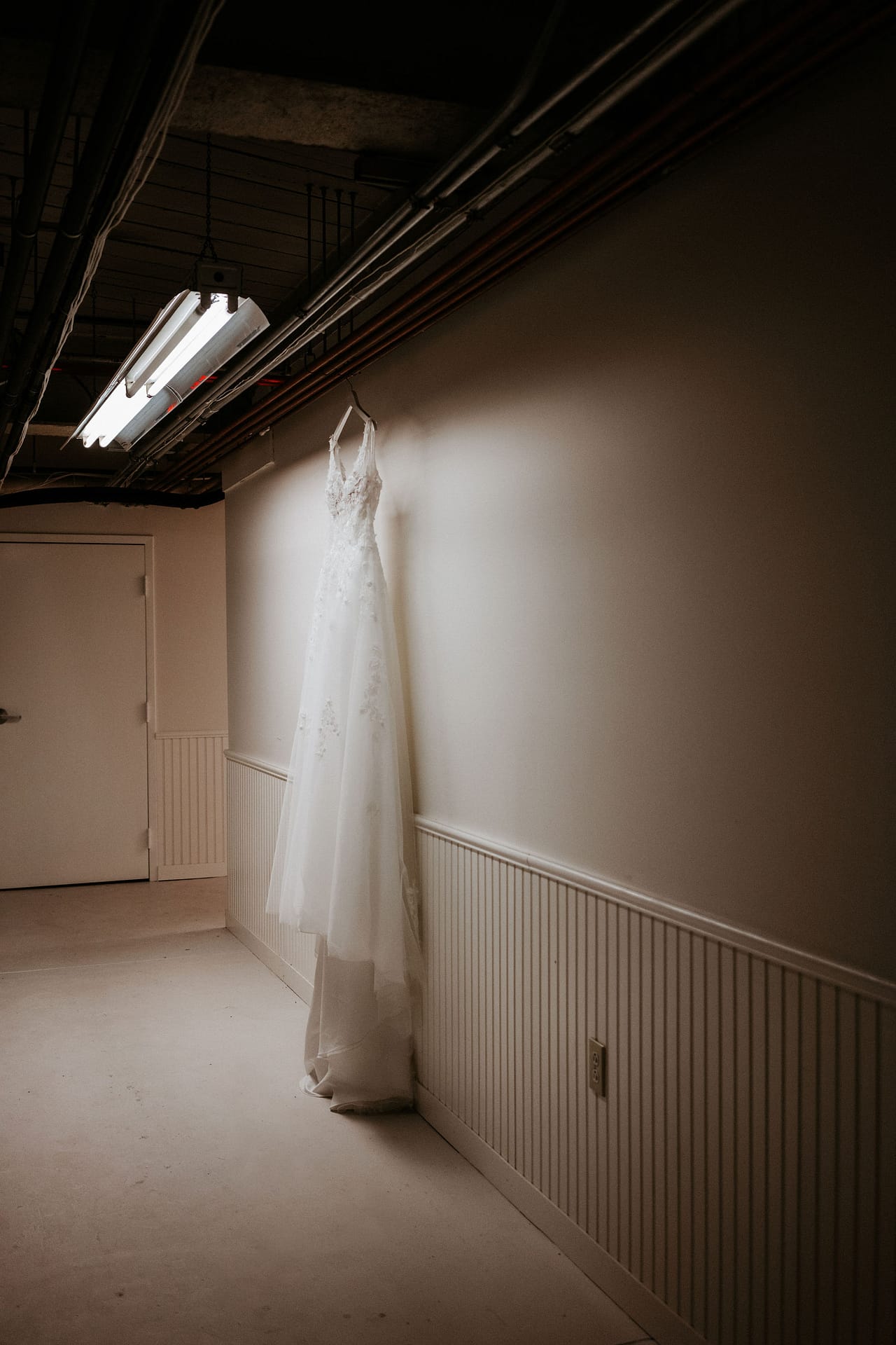 wedding dress hanging up in hallway