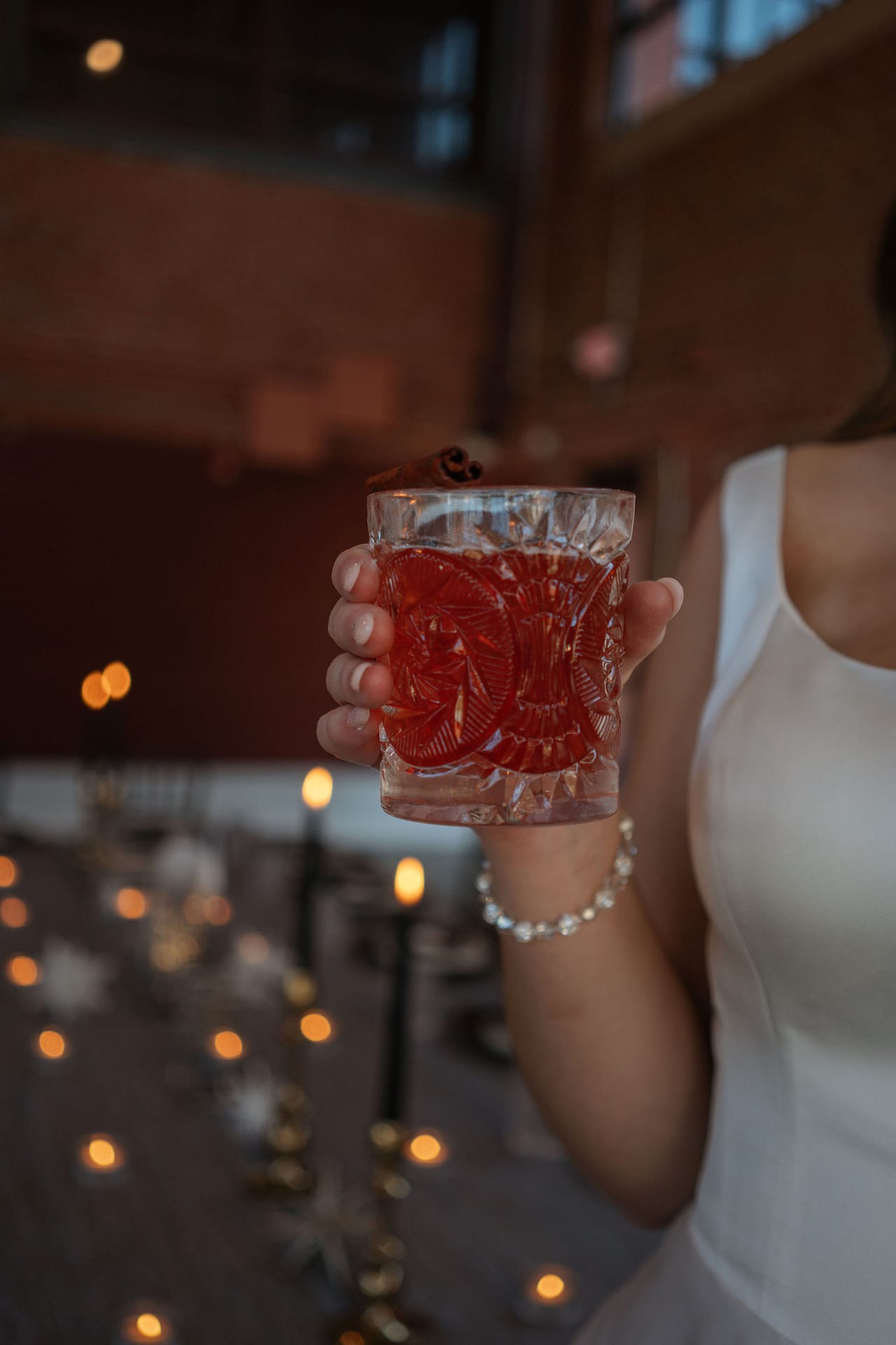 wedding guest holding red beverage in crystal glass