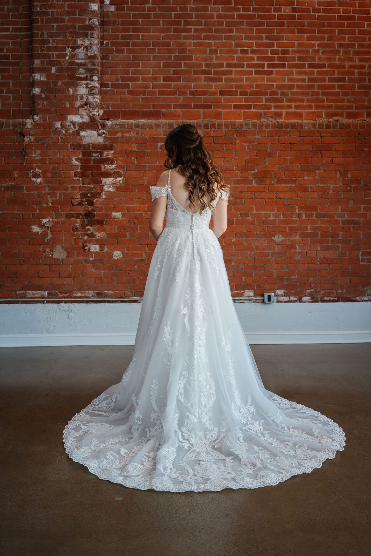 bride posing showing off her hair and dress details